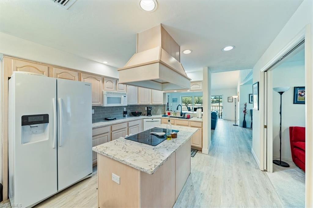 231 Via Perignon, Unit 204 Naples, FL 34119 - Photo 11 of 26 a kitchen with a refrigerator a sink and wooden cabinets
