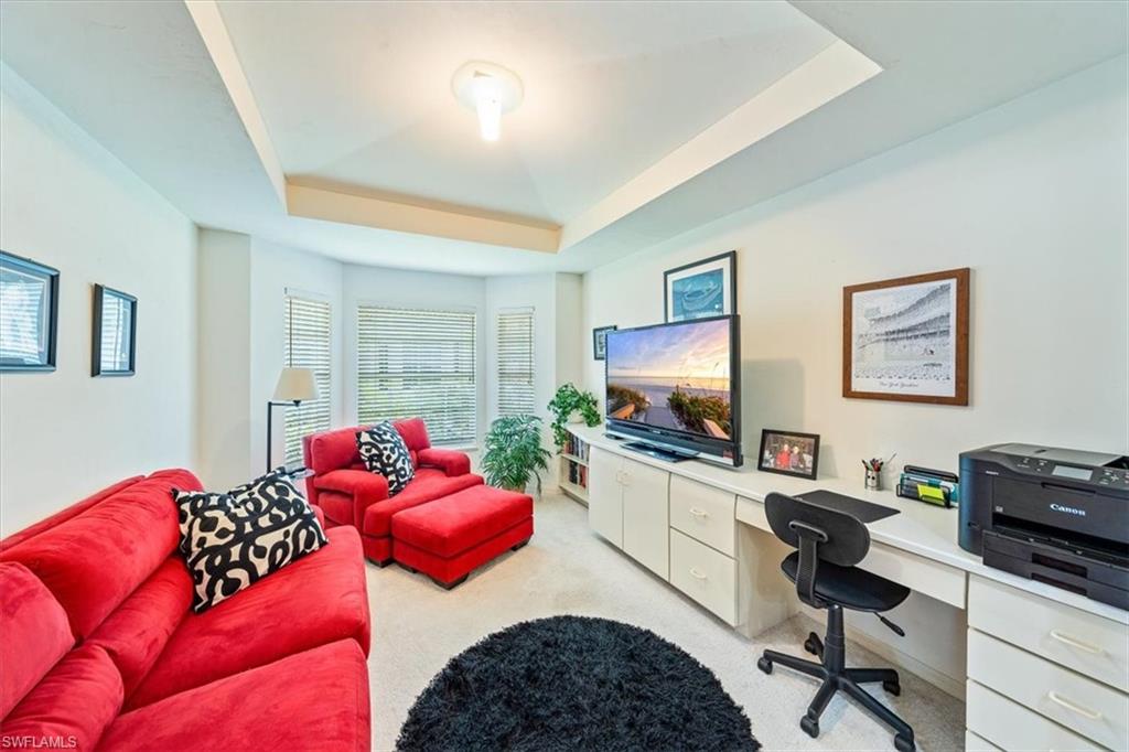 231 Via Perignon, Unit 204 Naples, FL 34119 - Photo 16 of 26 a living room with furniture and a flat screen tv