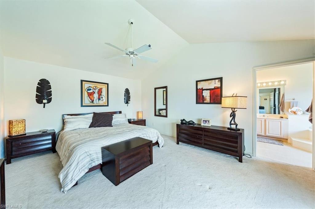 231 Via Perignon, Unit 204 Naples, FL 34119 - Photo 18 of 26 a spacious bedroom with a bed and a chandelier