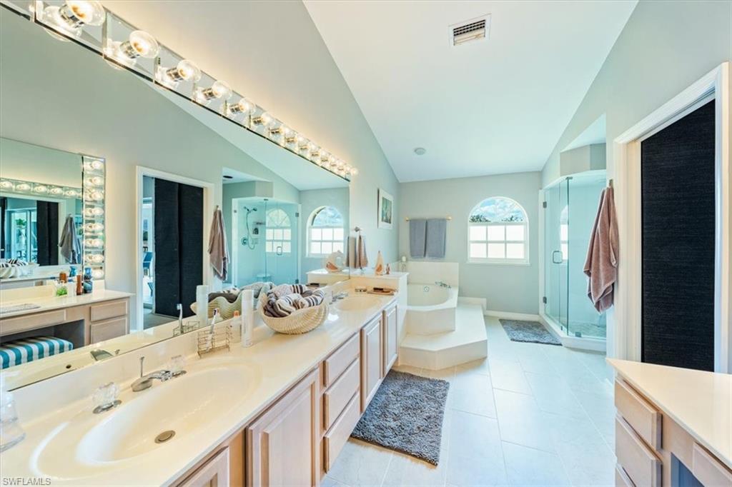 231 Via Perignon, Unit 204 Naples, FL 34119 - Photo 21 of 26 a spacious bathroom with a double vanity sink a large mirror and a bathtub