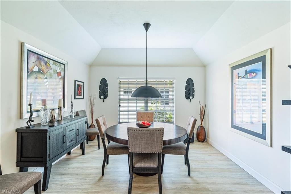 231 Via Perignon, Unit 204 Naples, FL 34119 - Photo 10 of 26 a dining room with furniture a chandelier and wooden floor