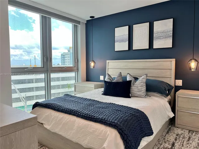 a bedroom with a large bed and a large window