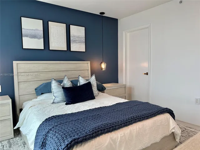 a bedroom with a large bed and a night stand