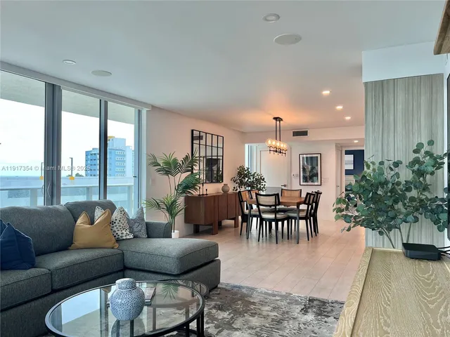a living room with furniture potted plant and a large window