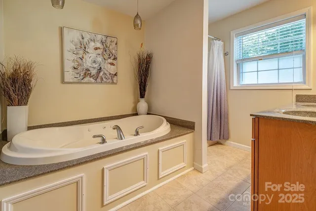 a bathroom with a tub sink and mirror