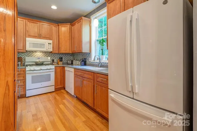 a kitchen with stainless steel appliances granite countertop a stove a sink dishwasher and a refrigerator