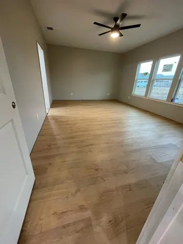 en empty room with windows and ceiling fan