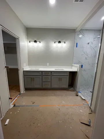 a view of an empty room with cabinet and mirrors