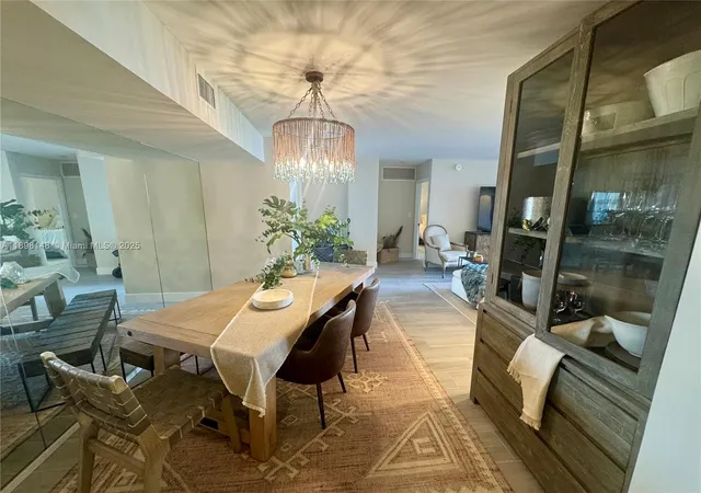a view of a dining room with furniture a chandelier and wooden floor
