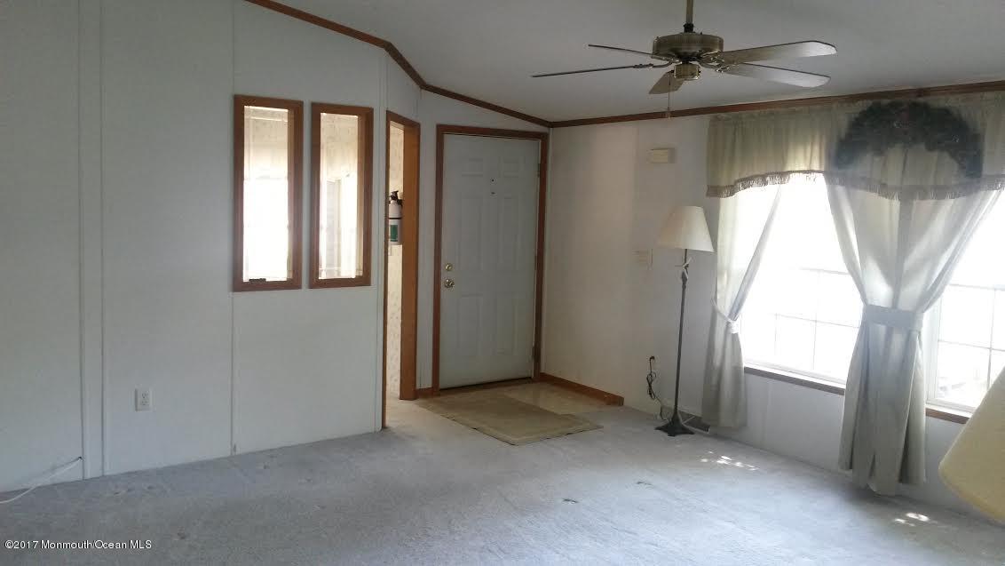 30 Village Road Morganville, NJ 07751 - Photo 4 of 25 an empty room with a window and a ceiling fan