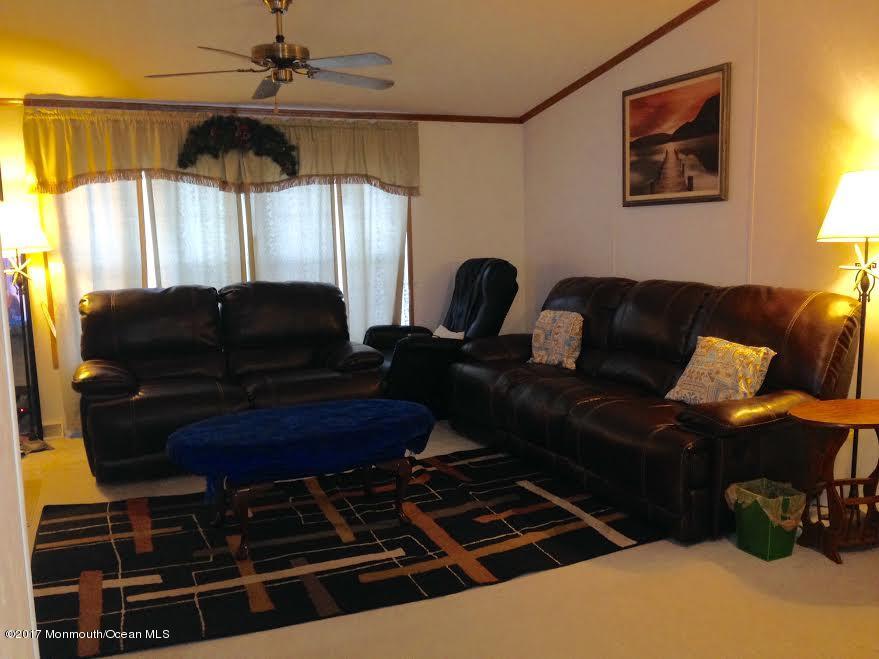 30 Village Road Morganville, NJ 07751 - Photo 6 of 25 a living room with furniture a lamp and a window