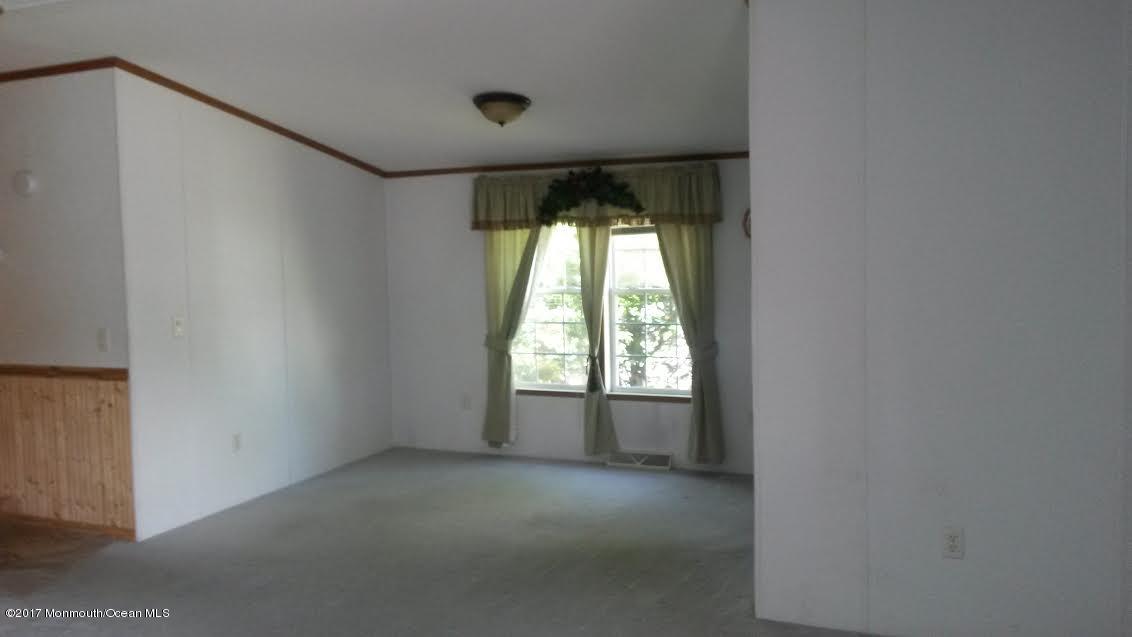 30 Village Road Morganville, NJ 07751 - Photo 8 of 25 an empty room with a fireplace and windows
