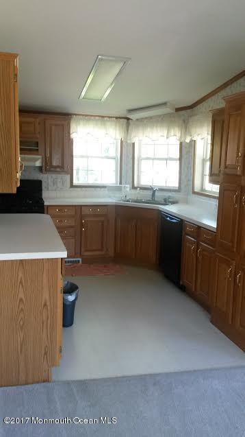 30 Village Road Morganville, NJ 07751 - Photo 9 of 25 a kitchen with stainless steel appliances a sink a stove and a refrigerator