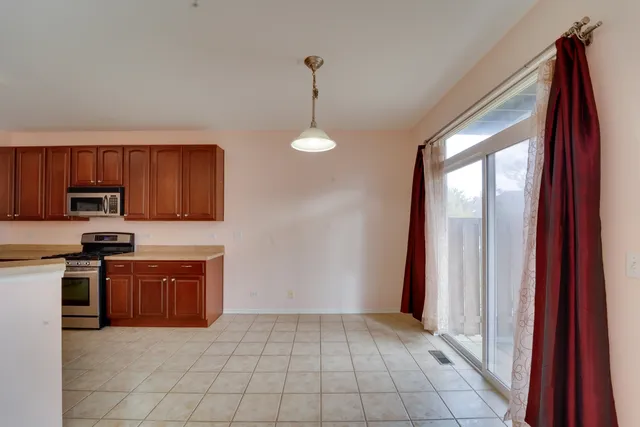 a view of an empty room with window and cabinet