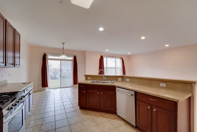 a kitchen with stainless steel appliances granite countertop a stove a sink dishwasher and a microwave oven with cabinets