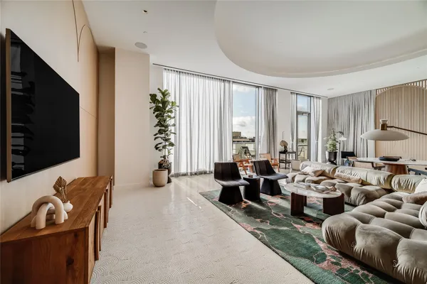 a living room with furniture large window and flat screen tv