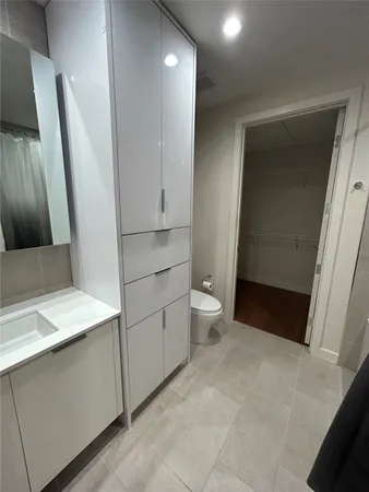 a bathroom with a sink a toilet and a mirror