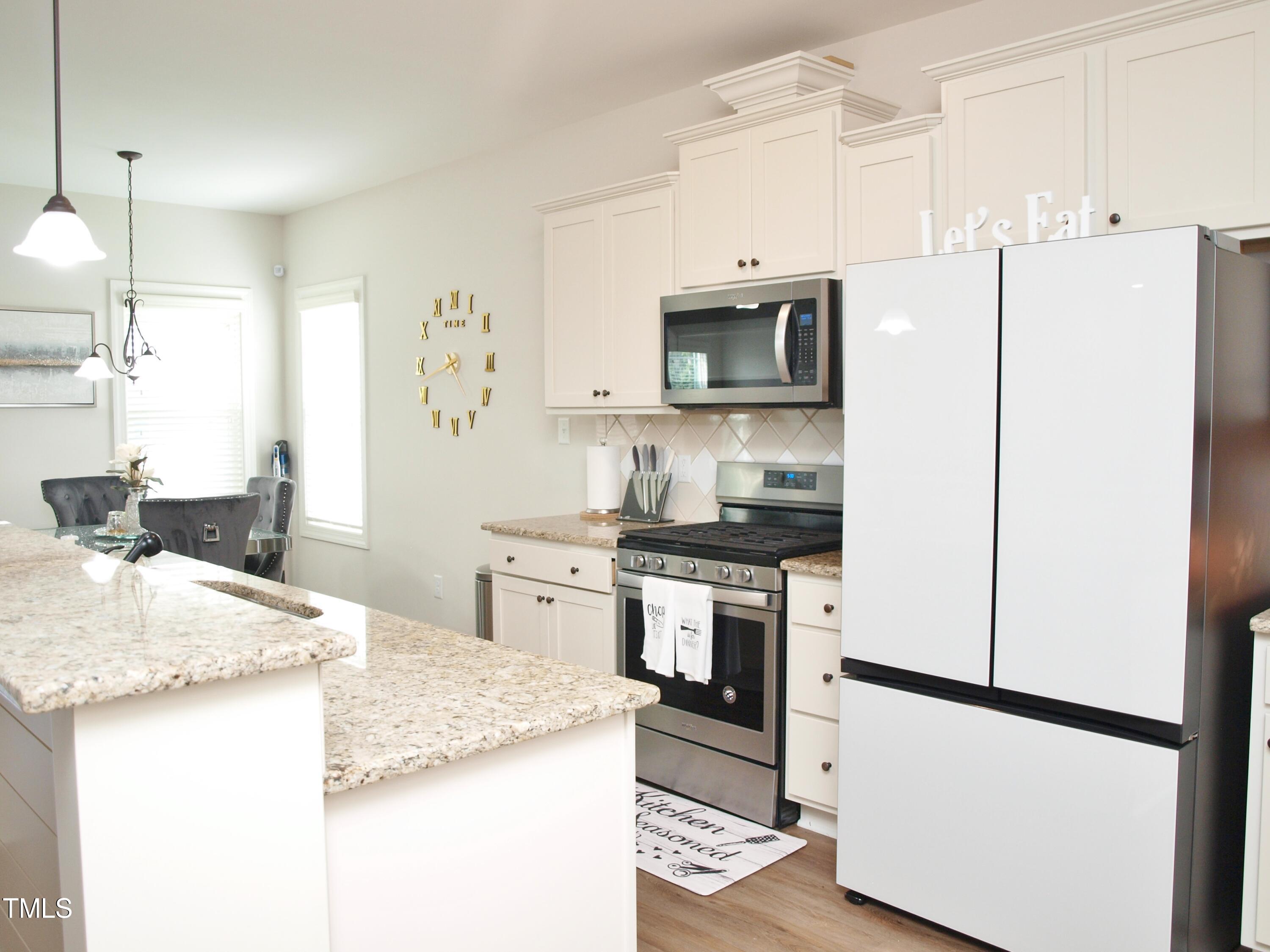417 Airedale Trail Garner, NC 27529 - Photo 11 of 26 a kitchen with granite countertop a refrigerator stove and sink