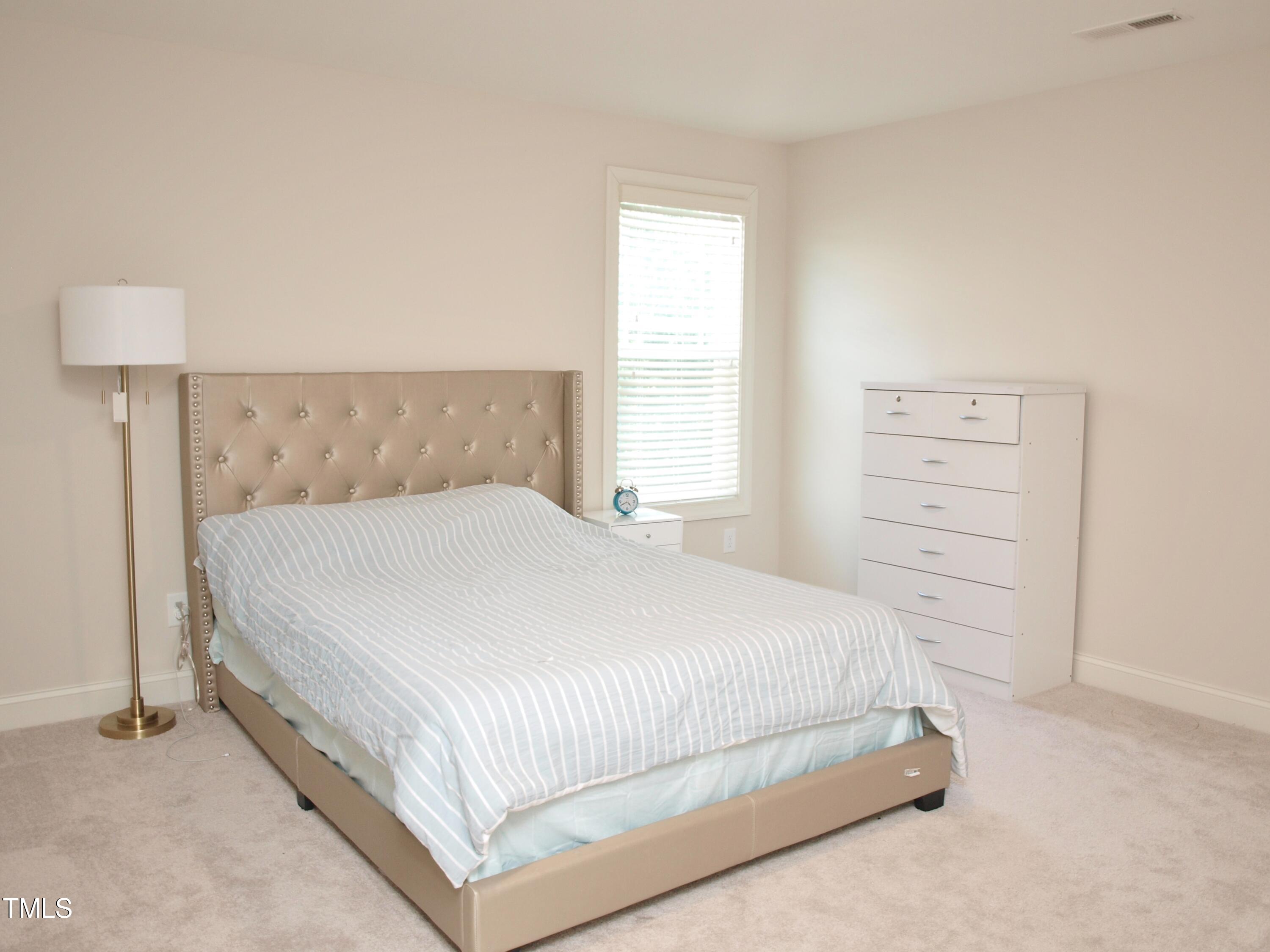 417 Airedale Trail Garner, NC 27529 - Photo 19 of 26 a large bed sitting in a bedroom next to a window and a lamp