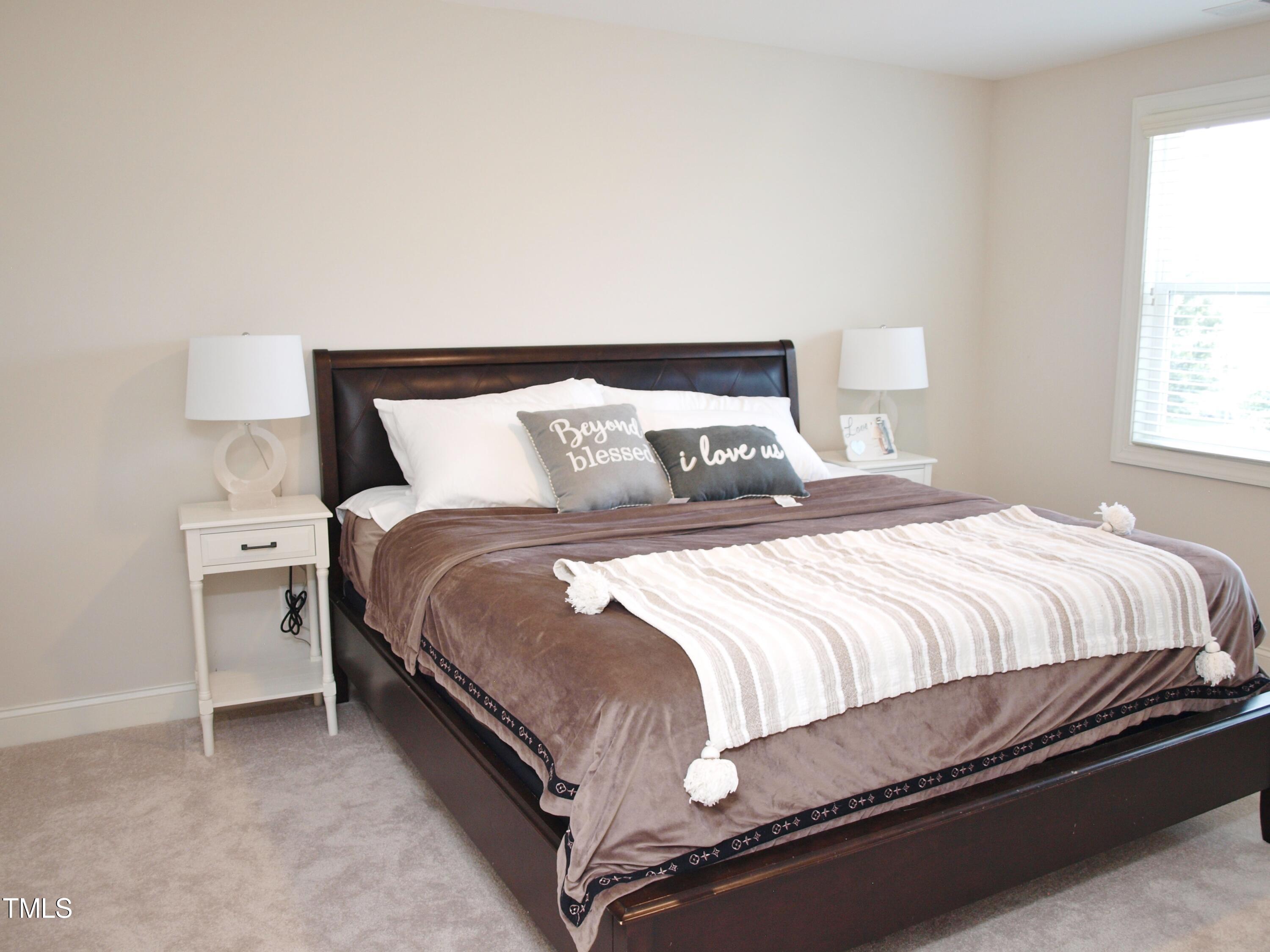 417 Airedale Trail Garner, NC 27529 - Photo 20 of 26 a large bed sitting in a bedroom next to a window with lamp