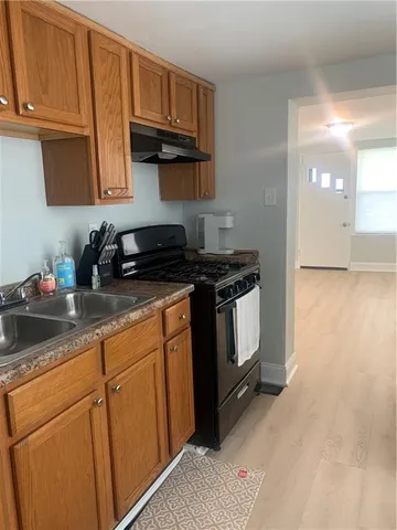 a kitchen with granite countertop a sink a stove and cabinets