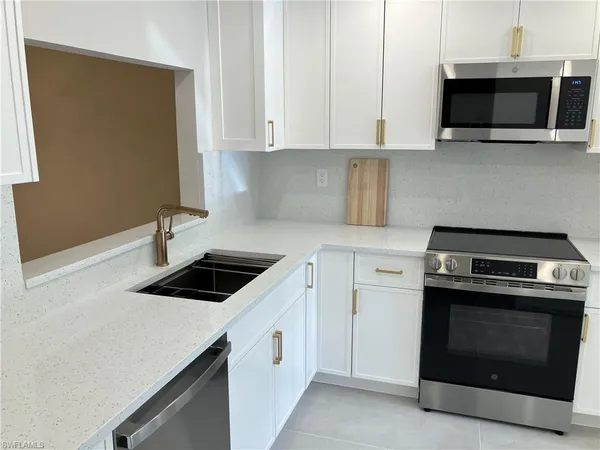 a kitchen with stainless steel appliances granite countertop a stove microwave and sink
