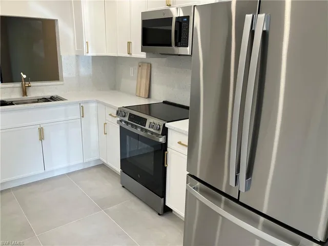 a kitchen with stainless steel appliances a stove microwave and refrigerator