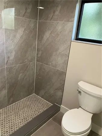 a bathroom with a toilet and a shower