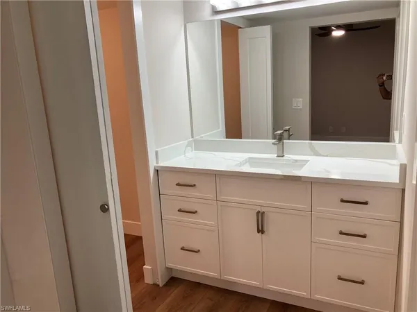 a bathroom with a granite countertop sink and a mirror