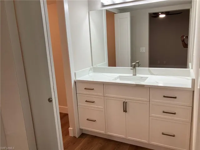 a bathroom with a granite countertop sink and a mirror