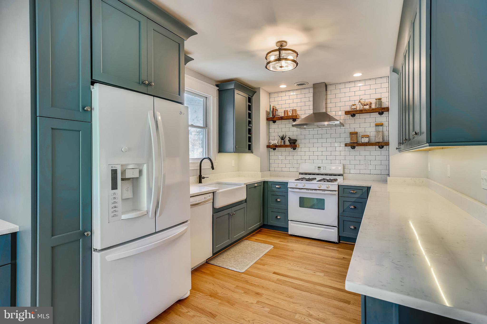 910 Overbrook Road Baltimore, MD 21239 - Photo 2 of 50 a large kitchen with stainless steel appliances granite countertop a refrigerator a sink dishwasher a stove and white countertops with wooden floor