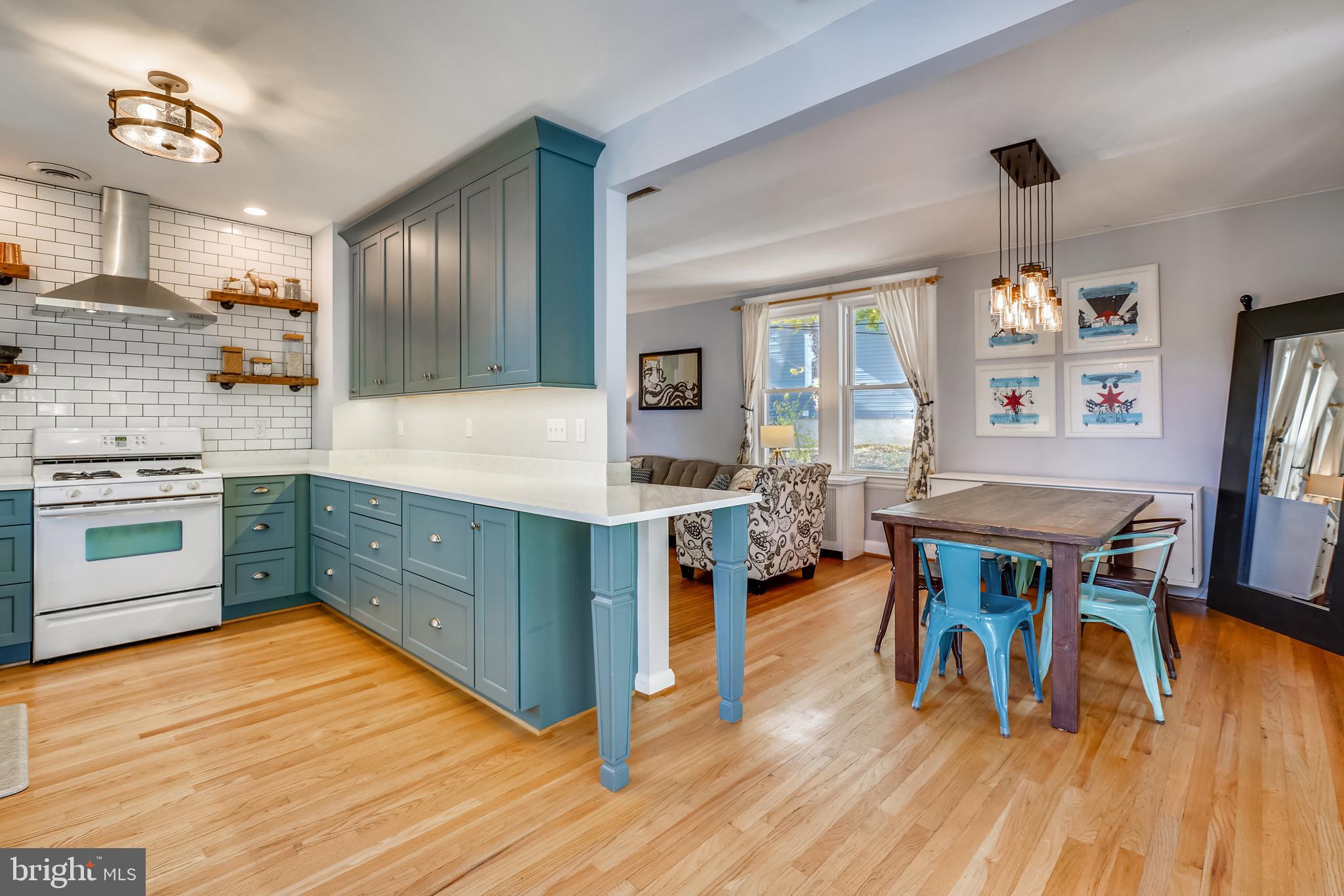 910 Overbrook Road Baltimore, MD 21239 - Photo 16 of 50 a kitchen with stainless steel appliances granite countertop a stove top oven a sink dishwasher a dining table and chairs with wooden floor