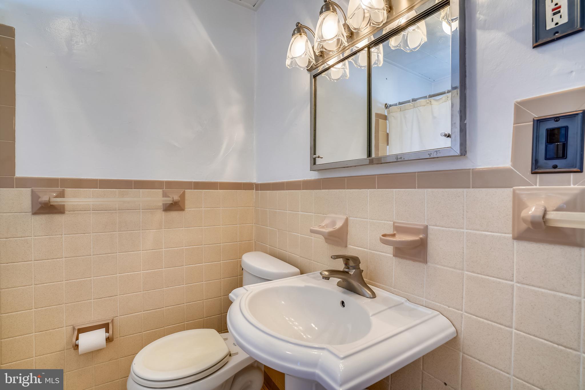 910 Overbrook Road Baltimore, MD 21239 - Photo 21 of 50 a bathroom with a sink a toilet and mirror
