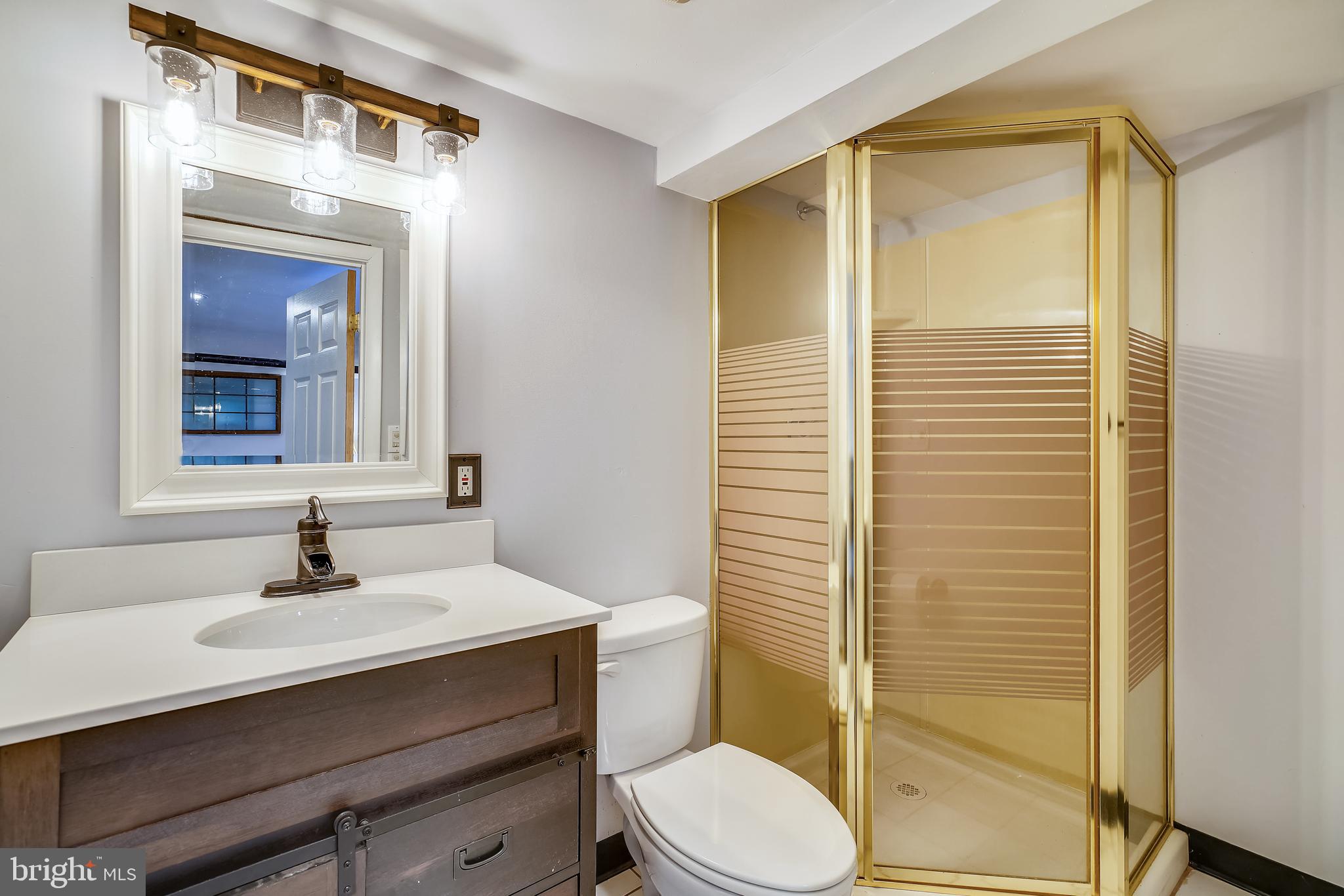 910 Overbrook Road Baltimore, MD 21239 - Photo 31 of 50 a bathroom with a sink a toilet a mirror and shower