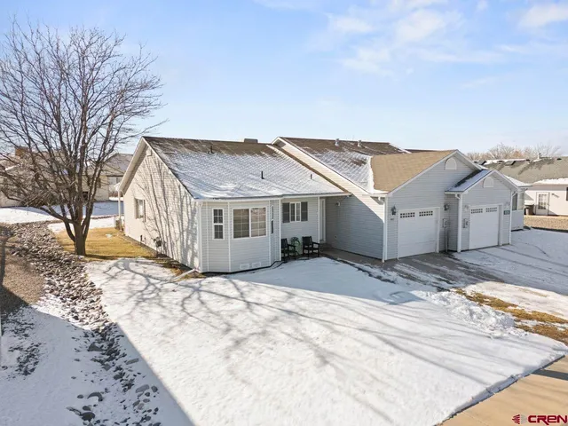 a view of a white house with a yard covered in snow
