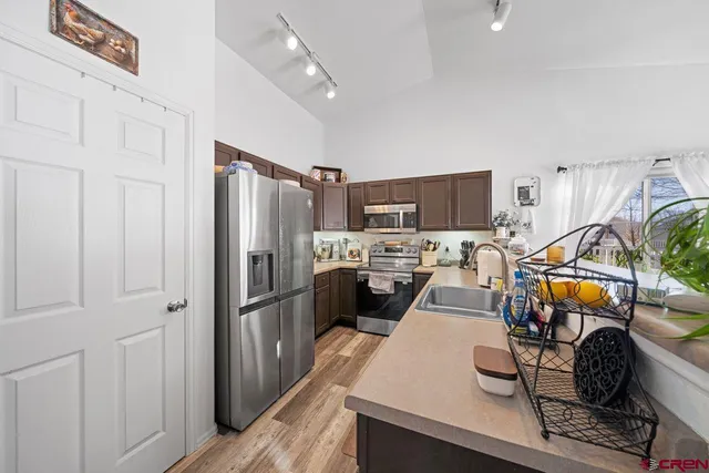 a kitchen with stainless steel appliances granite countertop a refrigerator stove and sink