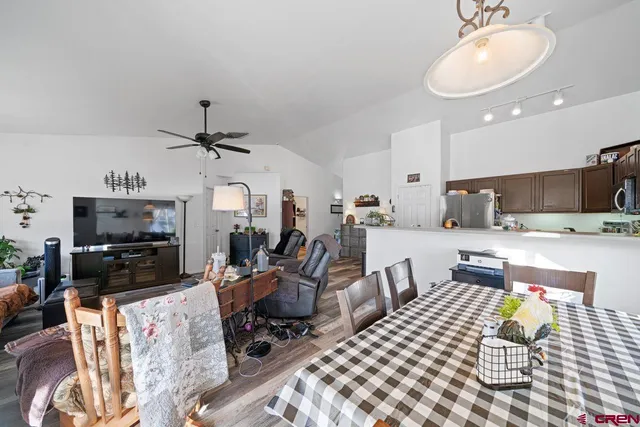 a living room with furniture a flat screen tv and kitchen view