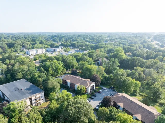 an aerial view of residential houses with outdoor space and trees