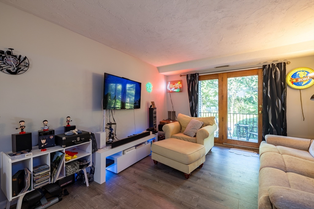 189 Littleton Road, Unit 10 Chelmsford, MA 01824 - Photo 4 of 15 a living room with furniture flat screen tv and a window