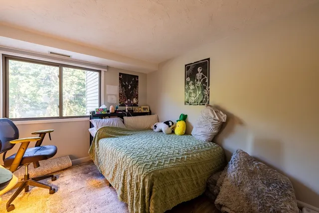 a bed room with a bed and a chair