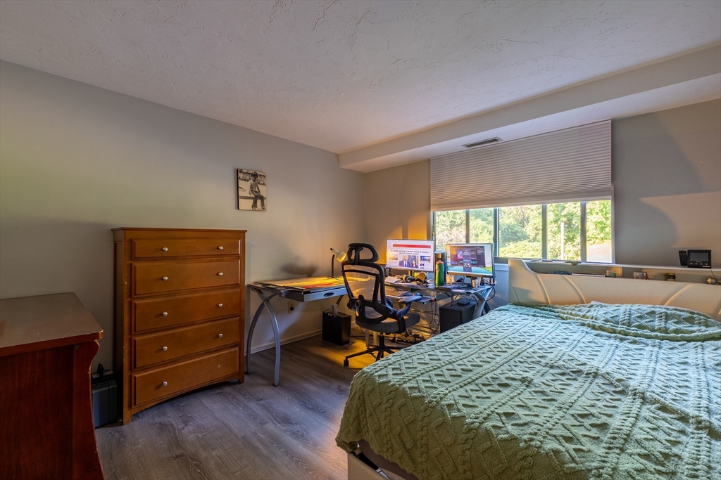 189 Littleton Road, Unit 10 Chelmsford, MA 01824 - Photo 8 of 15 a bed room with a bed and a chair