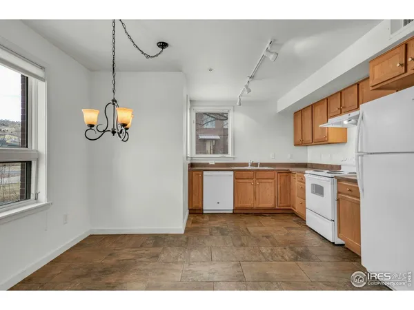 a kitchen with stainless steel appliances granite countertop a stove a sink dishwasher and a refrigerator with wooden floor