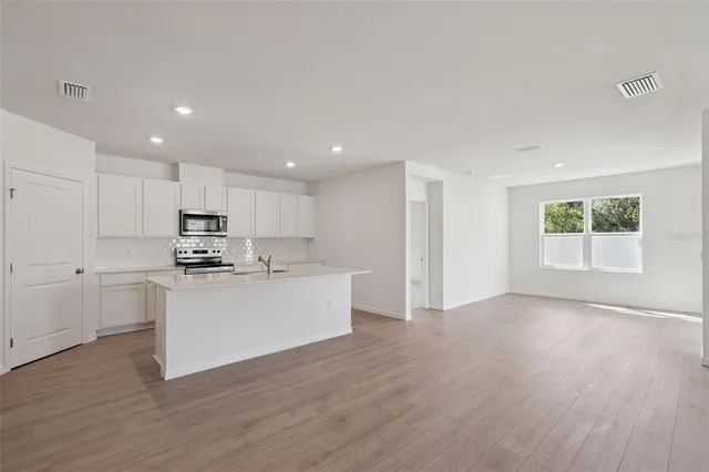 a view of kitchen with wooden floor and electronic appliances