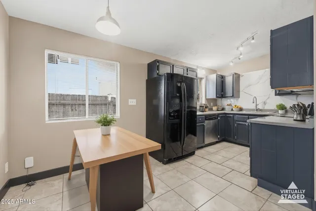 a kitchen with granite countertop a refrigerator a stove a sink dishwasher and white cabinets with wooden floor