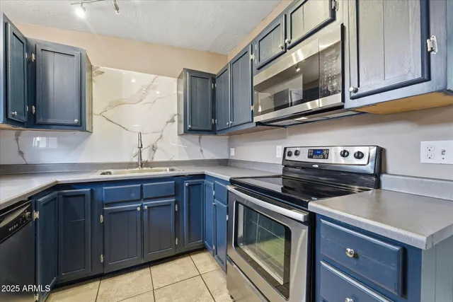 a kitchen with stainless steel appliances granite countertop a sink and a stove