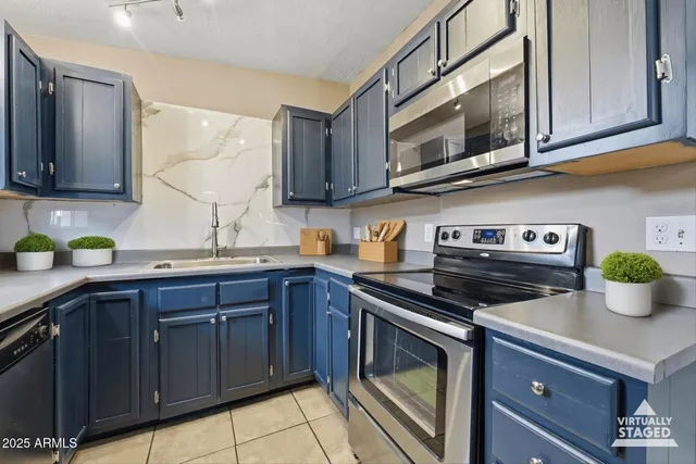 a kitchen with stainless steel appliances a stove a microwave a sink cabinets and a counter space