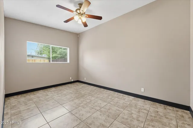 an empty room with windows and fan