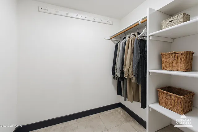 a view of walk in closet with clothes and shoes