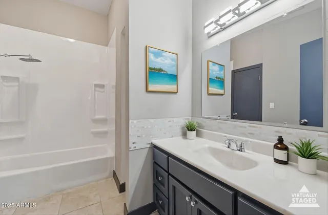 a bathroom with a granite countertop sink a mirror a vanity and a bathtub