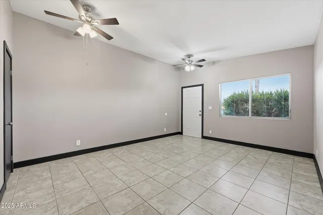 an empty room with windows and fan